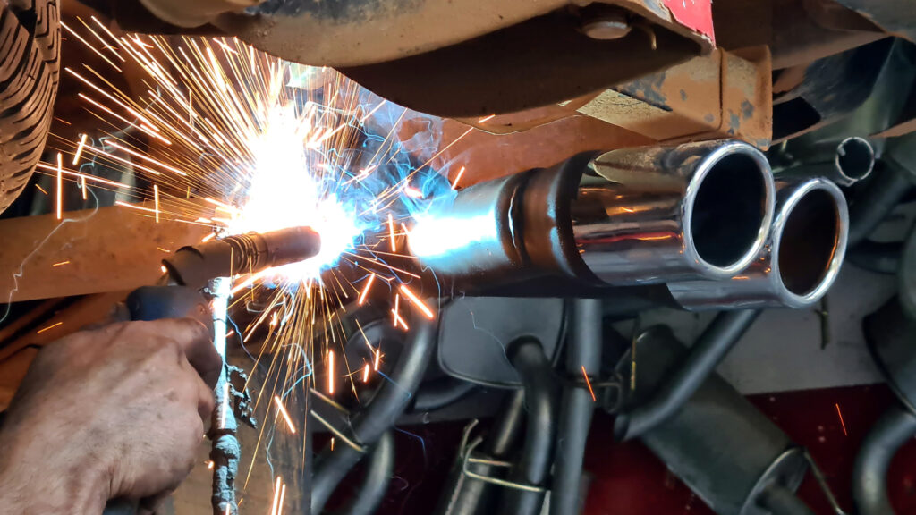 Mechanic welding a car exhaust