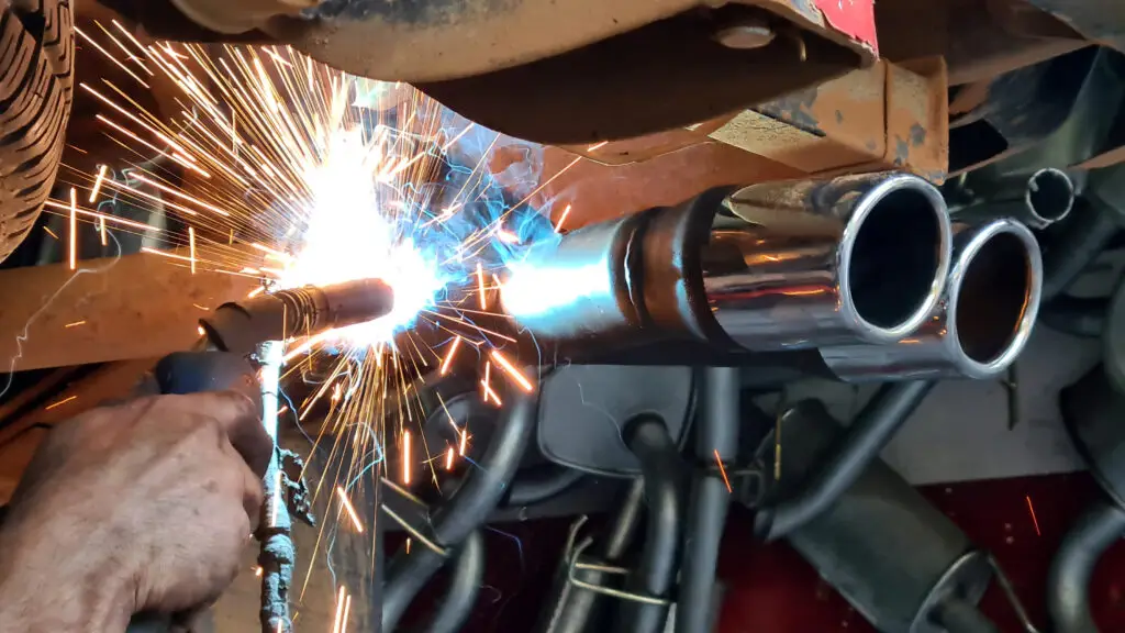 Mechanic welding a car exhaust